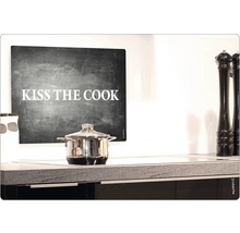 Kochtopf auf einem Induktionskochfeld unter einem Wandbild mit der Aufschrift Kiss the Cook