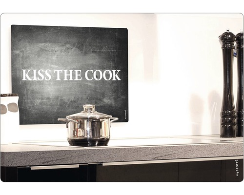 Kochtopf auf einem Induktionskochfeld unter einem Wandbild mit der Aufschrift Kiss the Cook