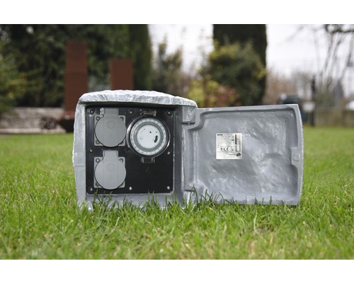 Gartensteckdose in Steinoptik mit Zeitschaltuhr auf Rasen