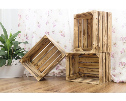 Dekorative Holzkisten im Innenraum mit Holzfußboden und floraler Tapete.