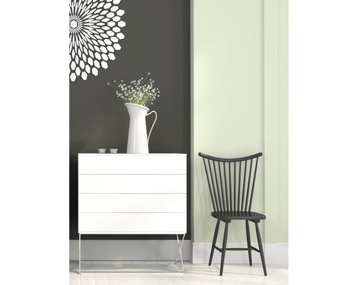 Szene mit einer weißen Kommode, einer Vase mit Blumen und einem schwarzen Holzstuhl.