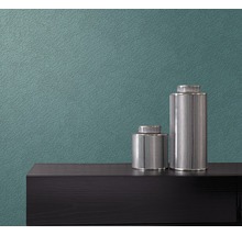 Nahaufnahme einer Wand mit einer Vliestapete und zwei dekorativen Gefäßen auf einer Kommode