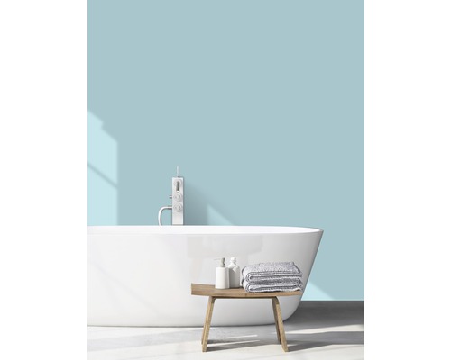 Helles Badezimmer mit freistehender Badewanne, Armatur, Handtüchern und Holzbank