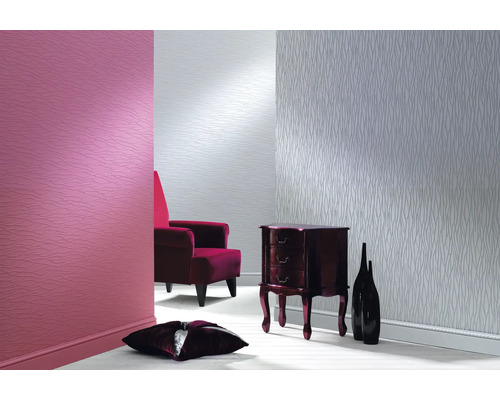 Wohnzimmer mit gemusterter Tapete, Sessel und Kommode