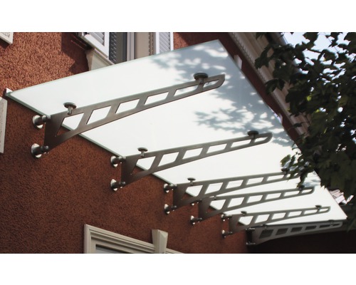 Glasvordach mit Metallhalterung an einer Hauswand
