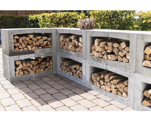 Gestapelte Betonsteine als Regal für Brennholz im Außenbereich.