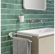 Badezimmeransicht mit Waschbecken, Armatur, Seifenspender und Handtuchhalter vor Wandfliesen
