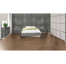 Schlafzimmer mit Bett, Nachttischen, Tapete und Laminatboden