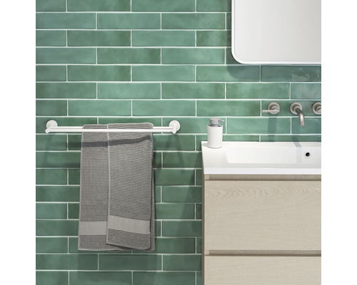 Modernes Badezimmer mit grünen Fliesen, Waschbecken, Handtuchhalter und Handtüchern