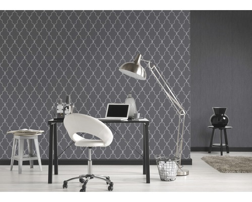 Arbeitszimmer mit gemusterter Tapete, Schreibtisch und Bürostuhl