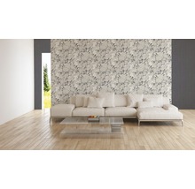 Wohnzimmer mit floral gemusterter Tapete, Sofa und Glastisch