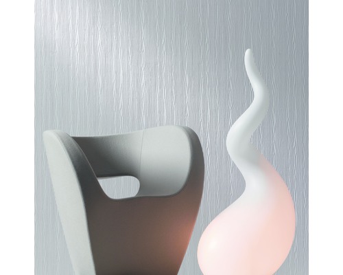 Szene mit strukturierten Tapeten, einem Sessel und einer dekorativen Lampe