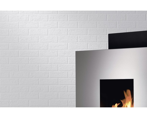 Detailaufnahme einer weißen Backsteinwand und eines Kamins mit Flammen