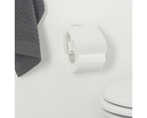 Toilettenpapierhalter mit Toilettenpapier und Handtuch an der Wand