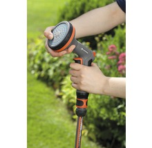 Person hält eine Gardena Brause in der Hand, verbunden mit einem Gartenschlauch.