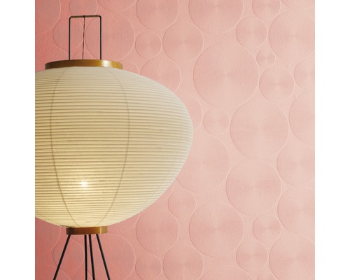 Raumansicht mit einer Stehlampe und einer rosafarbenen Tapete mit Kreismuster