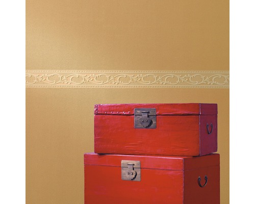 Zwei rote Holzkisten gestapelt vor einer Wand mit Bordüre