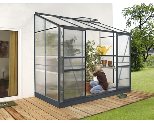 Anlehngewächshaus Vitavia Ida 3300 Hohlkammerplatten 4 mm 128x254 cm schwarz Anlehngewächshaus mit Frau bei der Gartenarbeit auf einer Holzterrasse
