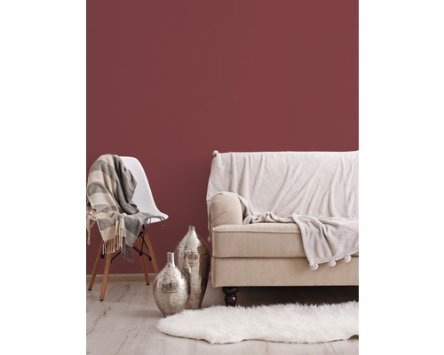 Wohnzimmer-Szene mit Sofa, Stuhl, Teppich und Dekoration vor einer Wand