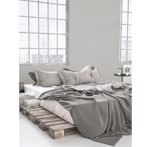 Schlafzimmer mit Bettgestell aus Holzpaletten, Bettwäsche und Kissen
