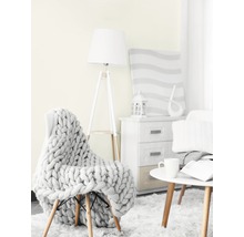 Wohnzimmer-Szene mit Sessel, Strickdecke, Stehlampe, Beistelltisch und Kommode