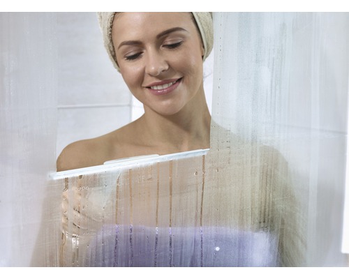 Frau wischt mit einem Abzieher eine Duschwand