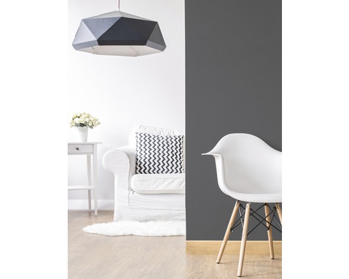 Wohnraum mit geometrischer Hängelampe, Sessel und Stuhl