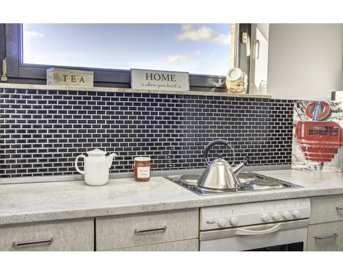 Küchenszene mit Mosaikfliesen, Teekanne und Kochfeld