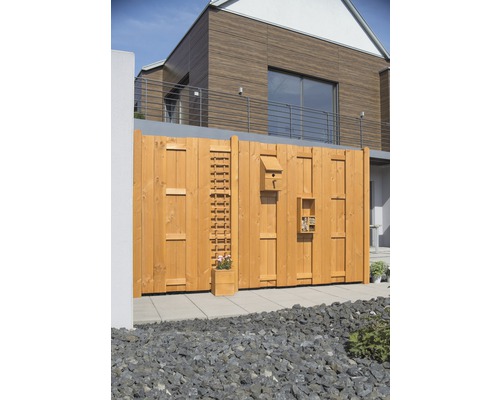 Holzzaun mit Vogelhaus, Kletterhilfe und Insektenhotel im Garten