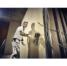 Handwerker verspachtelt eine Wand auf einer Baustelle