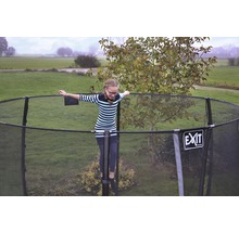 Mädchen balanciert auf einem Gartentrampolin mit Sicherheitsnetz. EXIT Logo.