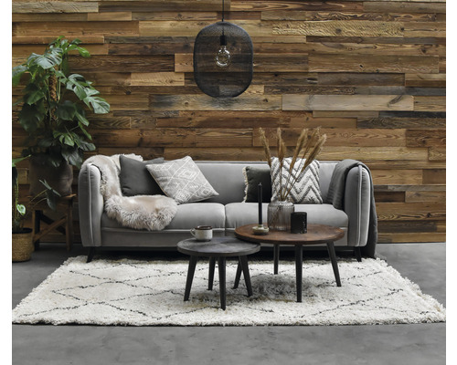 Wohnzimmer mit Sofa, Teppich, Couchtischen, Dekoration und Holzwand