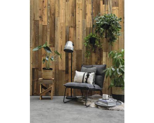 Wohnzimmer mit Holzvertäfelung, Sessel, Stehlampe und Pflanzen