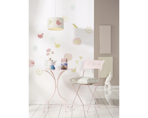 Zimmer mit Tisch, Stuhl, Lampe und Wanddekorationen für Kinder.