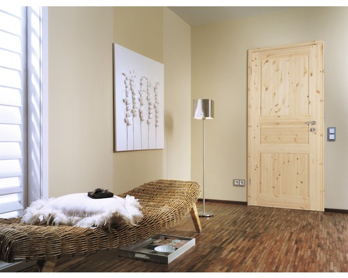 Zimmereinrichtung mit Holzboden, Rattanliege, Lampe und Holztür