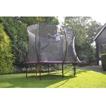 Mädchen springt auf einem Gartentrampolin mit Sicherheitsnetz