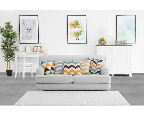 Wohnzimmer mit Sofa, Kissen, Teppich, Tisch, Stuhl, Kommode und Dekoration