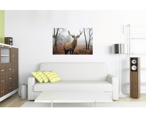 Wohnzimmer mit Sofa und Wandbild eines Hirsches im Wald
