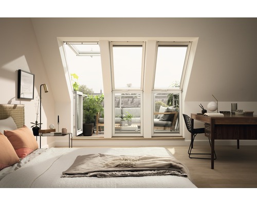 Schlafzimmer mit Dachfenstern, die auf einen Balkon mit Sitzmöbeln führen