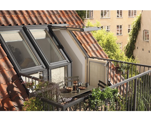 Dachfenster mit Balkon und Tisch mit Geschirr