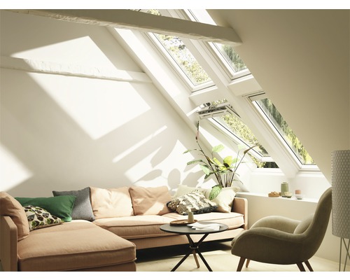 Wohnzimmer mit Dachfenstern, Sofa und Sessel in einem hellen Raum