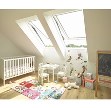 Helles Kinderzimmer mit Dachfenstern, Kinderbett, Tisch, Stühlen und Spielzeug