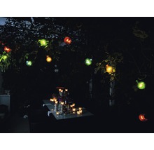 Gartenbeleuchtung mit Glühbirnen und Tischdekoration im Dunkeln.