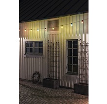 Außenansicht eines Hauses mit Lichterkette, Fenstern und Pflanzkästen.