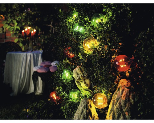 Beleuchteter Garten mit Kugel-Leuchten, Pflanze und Tischdekoration im Außenbereich