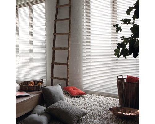 Heller Raum mit weißen Jalousien, Leiter und dekorativen Elementen.