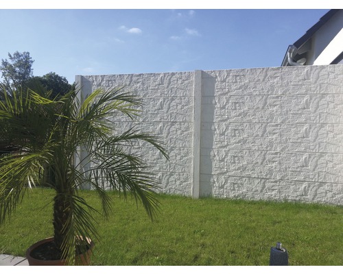 Betonzaun mit Steinmusterstruktur im Garten