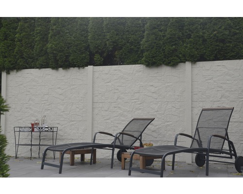 Gartenszene mit Steinmauer, Liegestühlen und Beistelltisch