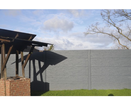 Gartenansicht mit Betonzaun und Grillplatz