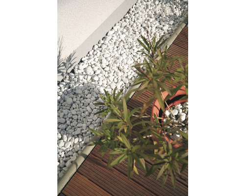 Gartenszene mit Zierkies, Holzterrasse und Topfpflanze